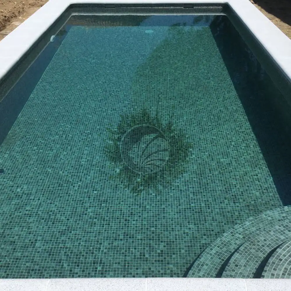 Gros plan d’une piscine avec carrelage mosaïque au fond et l’escalier