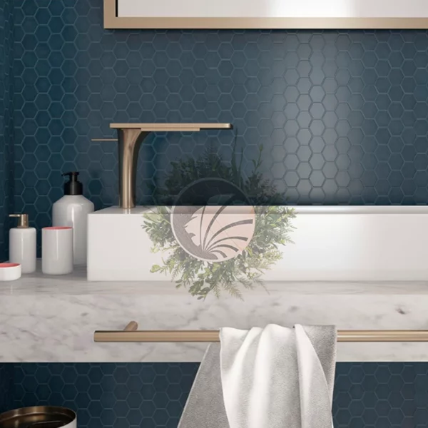 Mosaïque hexagonale bleu foncé derrière un lavabo de couleur claire, créant un contraste